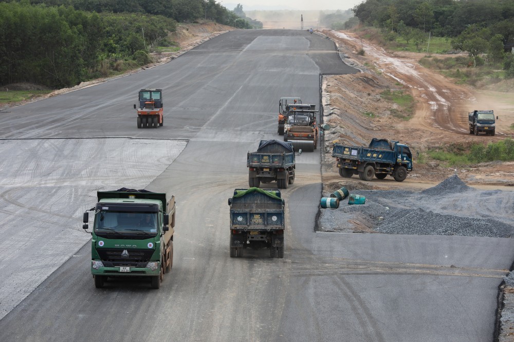 Đoạn đi qua xã Xuân Tâm (huyện Xuân Lộc), dự án đang được thảm nhựa, hàng chục xe cơ giới liên tục ra vào công trình.